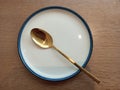 photo of a white plate with a gold spoon Royalty Free Stock Photo