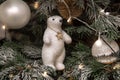 Photo of white teddy bear sitting on Christmas tree in snow, Christmas tree decor, festive concept, lights Royalty Free Stock Photo