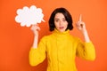 Photo of white thinking pensive charming pretty girl holding white cloud of thoughts while isolated with orange