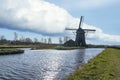 Photo of a windmill under a blue sky with a beautiful roll cloud, on the Papenvaart near Hazerswoude village, the Netherlands Royalty Free Stock Photo