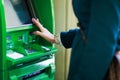 Photo of woman with clock on hand at green cash machine Royalty Free Stock Photo