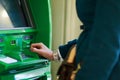 Photo of woman in coat at green cash machine Royalty Free Stock Photo