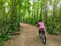 A photo of a woman enjoying a nice bike ride through the forest on a beautiful spring evening in the river valley