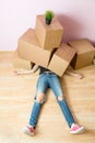 Photo of woman in jeans lying under cardboard boxes Royalty Free Stock Photo