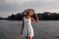 Photo of a woman in a straw hat. A beautiful happy young blonde in a white summer lace dress and a straw hat on her head Royalty Free Stock Photo