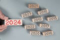 New Year 2024 Wooden Block and Human Hand Concept.