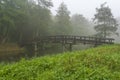 Photo of a wooden bridge over a ditch on a foggy morning in the Westerpark in Zoetermeer Royalty Free Stock Photo