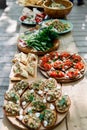 Photo of wooden table with snacks, sandwiches, pancakes with vegetables