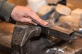 Photo of worker hand using sandpaper on metal workpiece