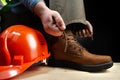 Worker with helmet lacing up leather boots Royalty Free Stock Photo