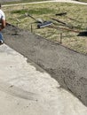 Photo of a worker leveling out poured wet cement