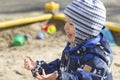 A smiling 2-year- old boy playing in a sandbox Royalty Free Stock Photo