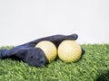 Photo of yellow golf balls and blue glove on artificial grass with white background Royalty Free Stock Photo