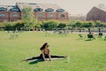 Photo of young active female model does split on karemat focused into distance dressed in activewear stays flexible motivated for