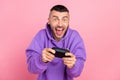 Photo of young addicted crazy man play console game joystick race isolated over pink color background