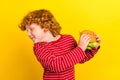 Photo of young addicted small little boy hold hands burger refuse diet food isolated on yellow color background