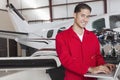 Portrait of young aeronautic engineer standing in front of an airplane propeller