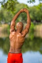 Photo of a young African American fitness model stretching in the park. Man posing shirtless showing muscles Royalty Free Stock Photo