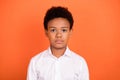 Photo of young african boy serious confident pupil clever education isolated over orange color background