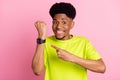 Photo of young african guy happy positive smile point finger smart watch device ad advice isolated over pink color