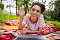 Photo of young african woman happy positive smile speak conversation video call meeting laptop wave hello outdoors Royalty Free Stock Photo