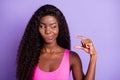 Photo of young african woman unhappy uncertain doubt look show fingers size isolated over violet color background