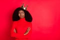 Photo of young african woman wear golden crown unhappy sad doubt crossed hands isolated over red color background