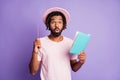 Photo of young afro amazed surprised handsome man male guy point pen in copyspace hold blue diary isolated on violet Royalty Free Stock Photo