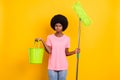 Photo of young afro girl unhappy sad upset clean home chores bucket duty cleaner isolated over yellow color background