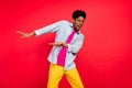 Photo of young afro guy hipster cool have fun dancer hip-hop disco party isolated over red color background Royalty Free Stock Photo