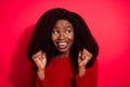 Photo of young afro woman happy positive smile rejoice victory fists hands lucky look empty space isolated over red