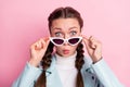 Photo of young amazed girl shocked surprised news fake novelty hands touch sunglass isolated over pink color background Royalty Free Stock Photo