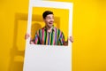 Photo of young amazed man in vintage shirt paper portrait frame shooting memories looking empty space isolated on yellow