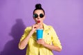 Photo of young amazed surprised beautiful girl woman drink soda with straw wear sunglasses isolated on purple color