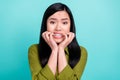 Photo of young asian girl frightened scared bite teeth fingers mistake anxious isolated over teal color background