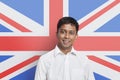Portrait of young Asian man in shirt smiling against British flag Royalty Free Stock Photo