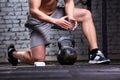 Photo of young athlete man while getting ready for crossfit training with dumbbells against brick wall. Royalty Free Stock Photo