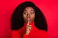 Photo of young attractive african woman cover lips finger keep secret shh silence isolated over red color background Royalty Free Stock Photo