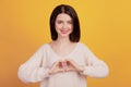 Photo of young attractive lady show fingers heart symbol romance valentine day isolated on yellow color background