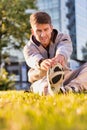 Young attractive man stretching his legs in park