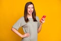 Photo of young attractive pretty happy smiling excited girl wink blink eye hold phone isolated on yellow color