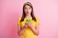 Photo of young attractive shocked amazed afraid scared girl hold cellphone bad news isolated on pink color background