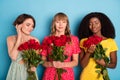 Photo of young attractive tender girls hold bouquet roses holiday spring isolated over blue color background Royalty Free Stock Photo