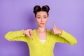 Photo of young attractive unhappy upset unsure girl showing thumb-up and thumb-down isolated on purple color background