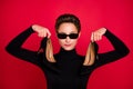 Photo of young attractive woman happy positive smile hold stilettoes wear eyeglasses isolated over red color background Royalty Free Stock Photo