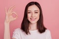 Photo of young attractive woman happy positive smile show okay alright sign great isolated over pink color background