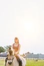 Portrait of young attractive woman riding horse in ranch Royalty Free Stock Photo