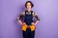 Photo of young attractive woman serious confident builder repair restoration tools isolated over purple color background