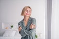 Photo of young beautiful blonde bob hair lady wearing soft grey nightwear sleepy mood hugging herself  at home Royalty Free Stock Photo