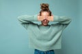 Photo of young beautiful blonde woman with sincere emotions wearing casual blue pullover over blue background